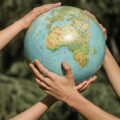 People holding a globe together