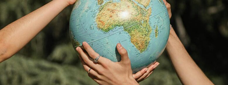 People holding a globe together
